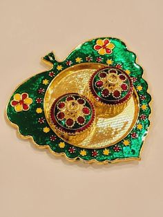 a green and gold plate with two cupcakes on it's side in the shape of a flower