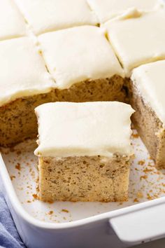 slices of carrot cake with white frosting in a pan