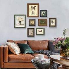 a living room filled with furniture and framed pictures on the wall above it's coffee table