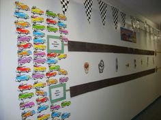 the wall is decorated with colorful cars and checkered flags hanging on it's sides