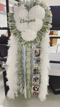 a heart shaped wreath with the name eloyna on it and pictures hanging from it's sides