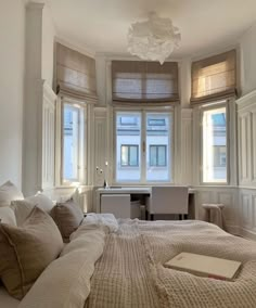 a large bed sitting next to two windows in a bedroom