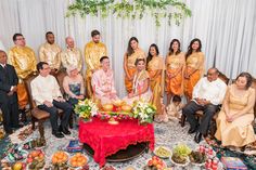 a group of people posing for a photo in front of a table with food on it