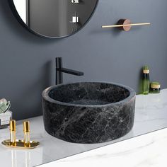 a marble sink in front of a round mirror