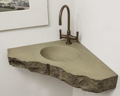 a stone sink with a faucet on it in a bathroom next to a framed photo