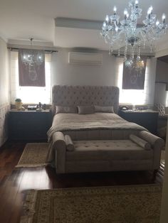 a bedroom with a large bed and chandelier