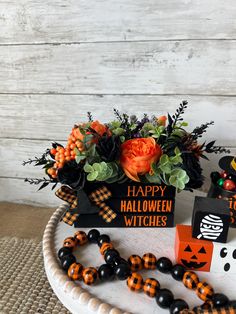 a halloween decoration on a white plate with black and orange decorations in the centerpiece