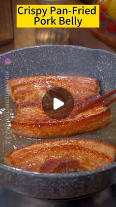 crispy pan - fried pork belly in a frying pan with chopsticks