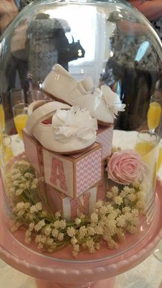 a cake under a glass dome on top of a table with flowers and other items