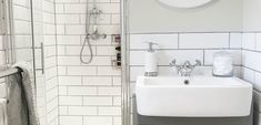 a bathroom with a sink, mirror and towel rack in it's corner next to the shower