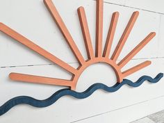 a wooden sign with the shape of a sun and waves on it's side