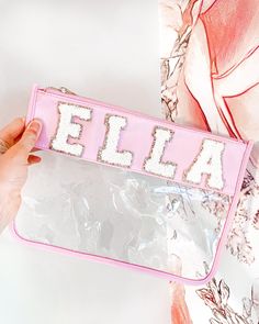 a hand holding a clear plastic bag with the word ella on it