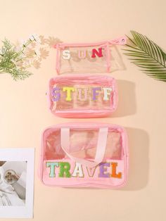 two pink suitcases sitting on top of a table next to a plant and photo