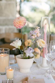 the table is set with flowers and candles