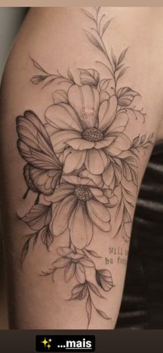 a woman's thigh with flowers and butterfly tattoos on her leg, which is black and white