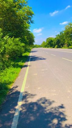 an empty road with trees on both sides