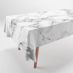 a white table cloth with marble pattern on it and wooden legs in front of the table