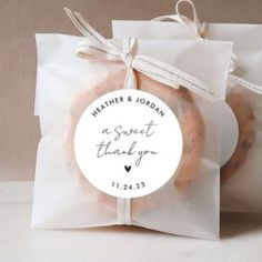 two donuts in a bag tied together with a white ribbon on the front and back