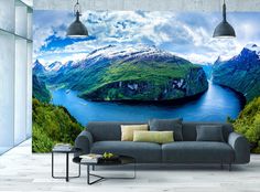 a living room with a couch, table and large wall mural in the middle of it