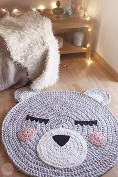 a crocheted bear rug is on the floor next to a teddy bear hat