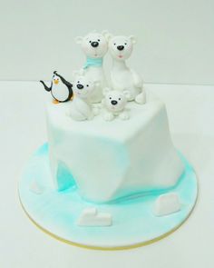 a cake decorated with polar bears and penguins on top of an ice floet