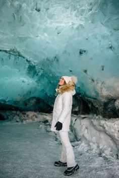 a woman standing in front of an ice cave