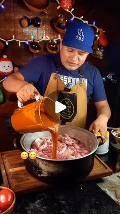 a man pouring sauce into a pot filled with meat