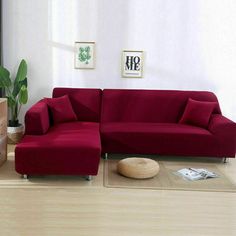 a red couch sitting on top of a hard wood floor next to a wooden table