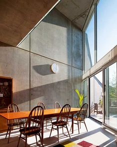 a dining room table and chairs in front of large windows