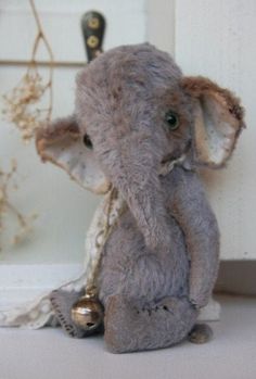 an elephant stuffed animal sitting on top of a white counter next to a door way