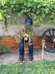 a man sitting in front of a wheel with flowers and plants growing out of it