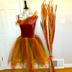 a dress made out of tulle and feathers sitting on top of a mannequin