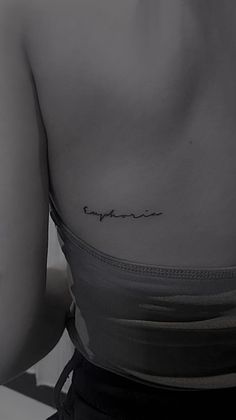 the back of a woman's upper body with an inscription on her left side