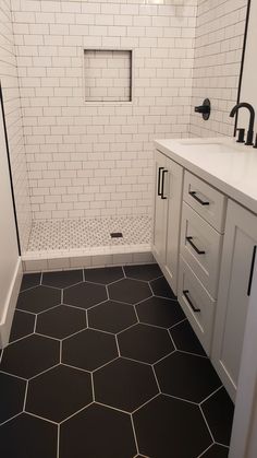 a bathroom with black and white hexagonal tiles