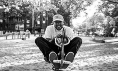 a man kneeling down on top of a tire swing