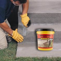 a man in blue shirt and yellow gloves painting steps