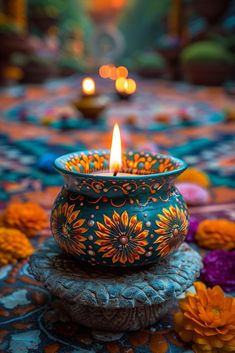 a lit candle sitting on top of a table covered in flowers