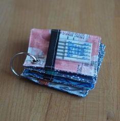 three small wallets are stacked on top of each other, one has a keychain attached to it