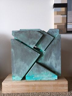 a sculpture is sitting on a wooden block