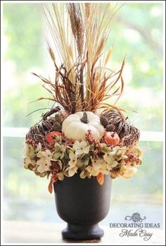 a vase filled with flowers and plants on top of a window sill