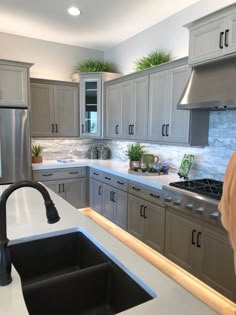 a kitchen with gray cabinets and white counter tops