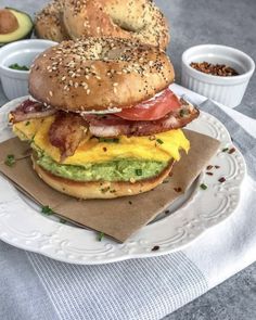 a bagel sandwich with bacon, cheese and avocado