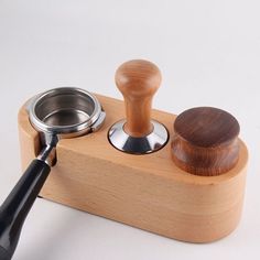 a close up of a wooden object with a metal bowl on it and a plunger in the middle