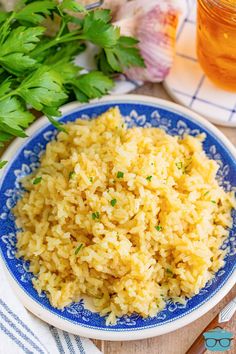 a blue and white plate filled with rice next to some parsley on a table