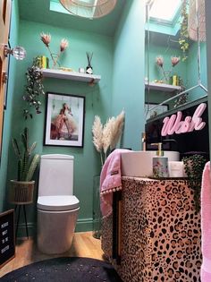 a bathroom with green walls and leopard print decor