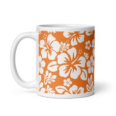 an orange and white coffee mug with flowers on it