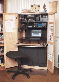 an office cubicle with a computer on the desk and many other items in it