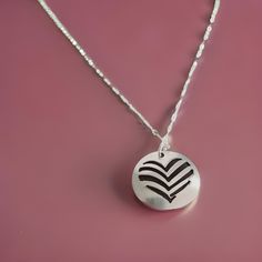 This delicate necklace, featuring a geometric heart is a symbol of love, peace, and tranquility. Crafted with care, the pendant is handmade using a unique clay process and then kiln-fired to perfection. Its polished finish adds a touch of elegance to this meaningful piece. The necklace is suspended on an 18-inch sterling silver oval flat cable chain, known for its sparkle and durability. Sourced from Rio Grande, this high-quality chain complements the pendant beautifully. Presented in a lovely gift box, this necklace is ready to be cherished by someone special - perhaps even yourself! Each pendant is lovingly handcrafted in my studio. I carefully shape the clay, fire it in a kiln, and then meticulously sand and polish it to achieve a lustrous finish. This intricate process ensures that eve Geometric Heart, Precious Metal Clay, Metal Clay, Love Symbols, Delicate Necklace, Fine Silver, Heart Necklace, Precious Metals, Lovely Gift