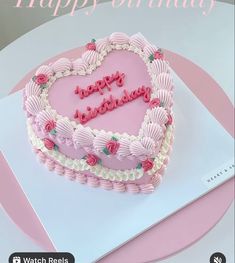 a heart shaped birthday cake with the words happy birthday written on it in pink frosting