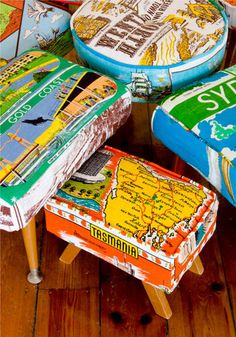 colorful stools are stacked on top of each other in front of a wooden floor